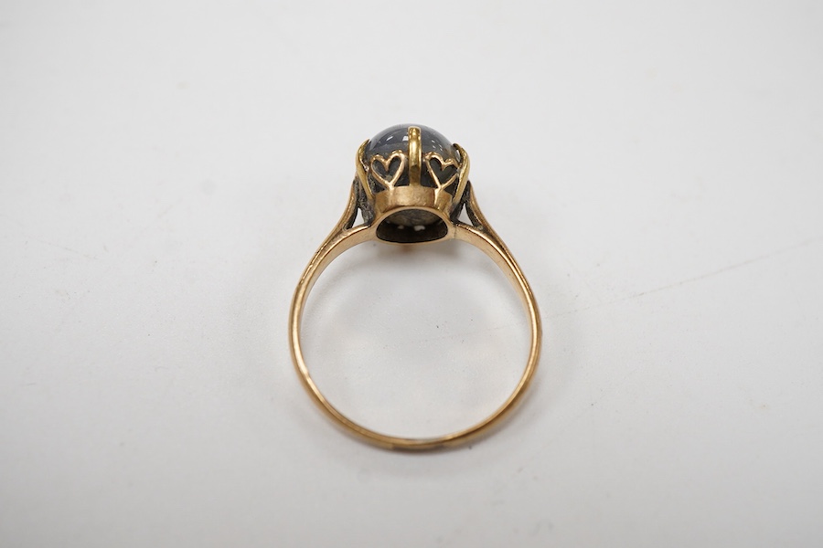 A yellow metal and single stone claw set star sapphire ring, size P, the stone approx. 9mm in diameter.